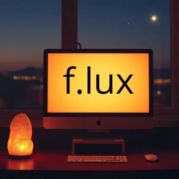 A computer screen displays the f.lux logo, with a warm orange light. A lamp and a salt lamp sit on a desk in a dimly lit room.