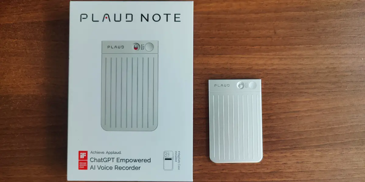 Plaud Note AI voice recorder alongside its packaging on a wooden surface.