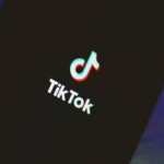 A smartphone screen displaying the TikTok logo with a dark background.